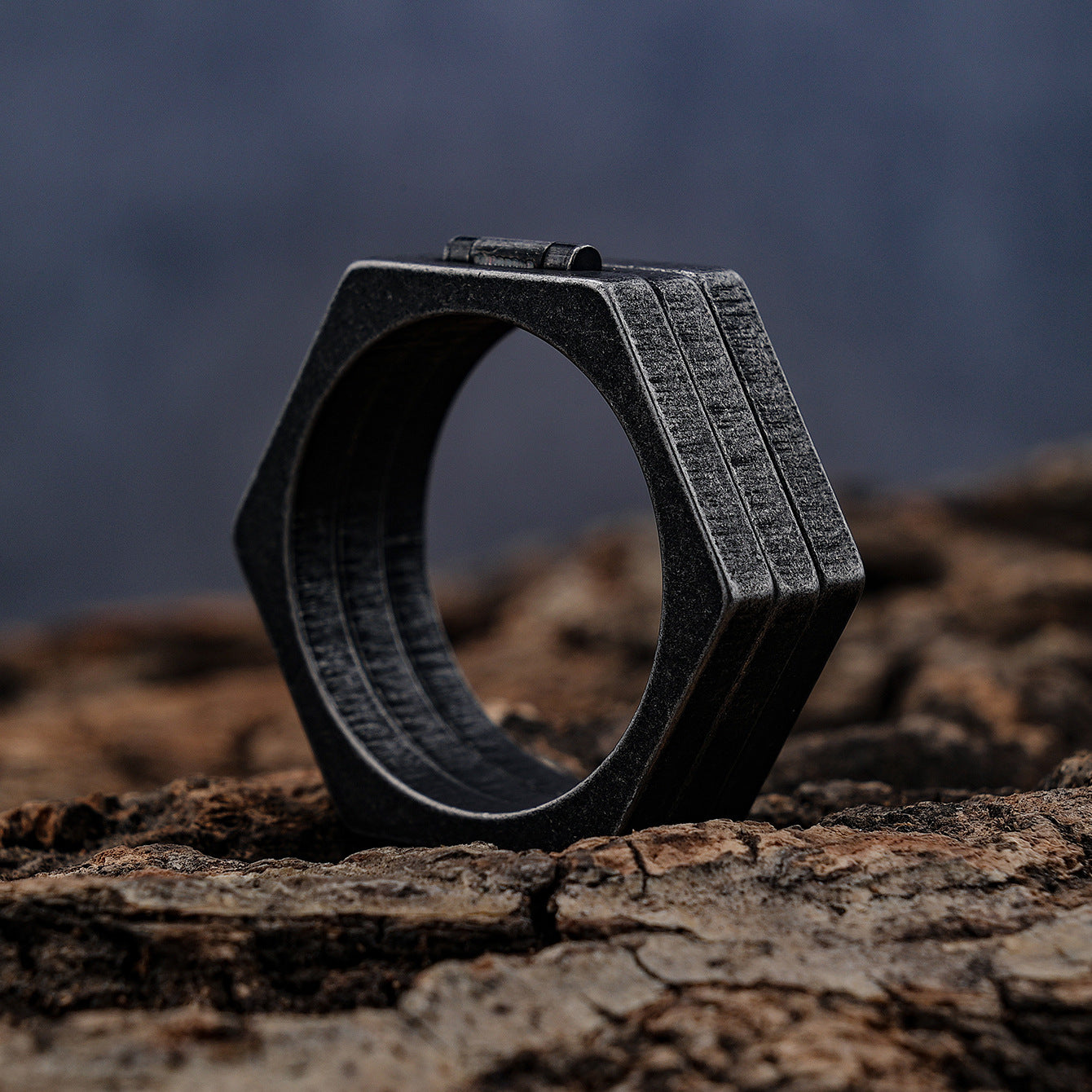 A black Maramalive™ Retro Titanium Steel Ring sitting on a piece of wood.