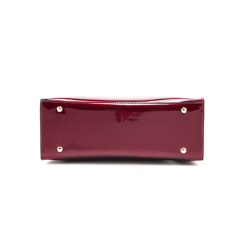 A burgundy Patent leather handbag with two purses, a wallet, and a zipper pocket for convenience.