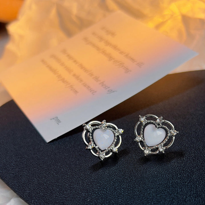 A pair of Sparkling Opal Heart Shape With Diamond Stud Earrings by Maramalive™ on a piece of paper.