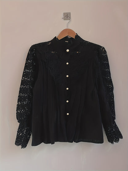 A Plus Size Elegant Blouse, Women's Plus Solid Contrast Lace Lantern Sleeve Button Up Mock Neck Shirt Top by Maramalive™ is hanging on a wooden hanger against a plain wall.