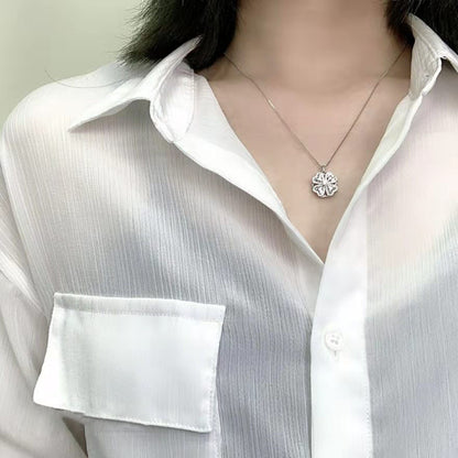 A woman wearing a Rotating Clover Necklace with a flower on it, from Maramalive™.