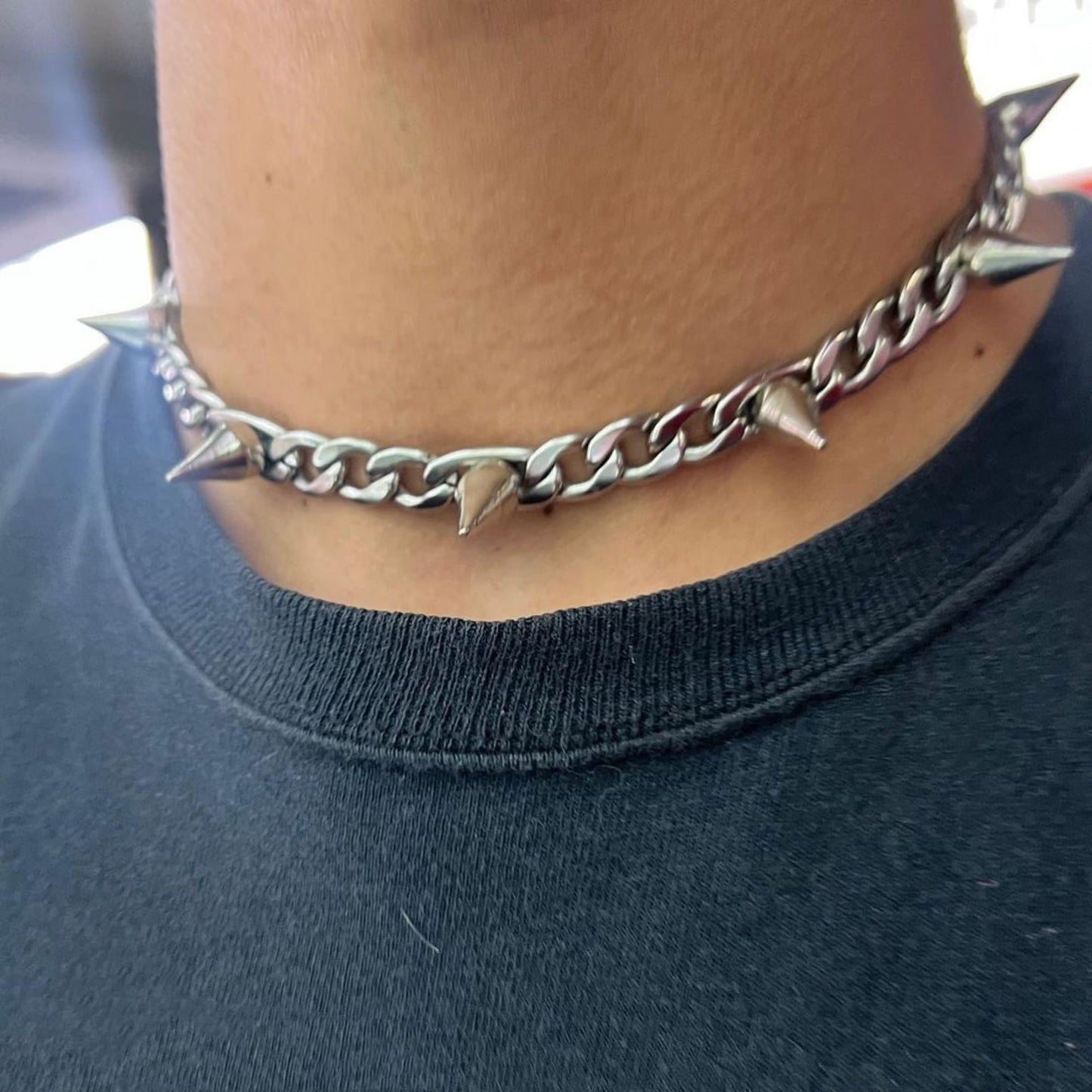 A man wearing a Vintage Punk Rock Neckchain from Maramalive™ with spikes on it.
