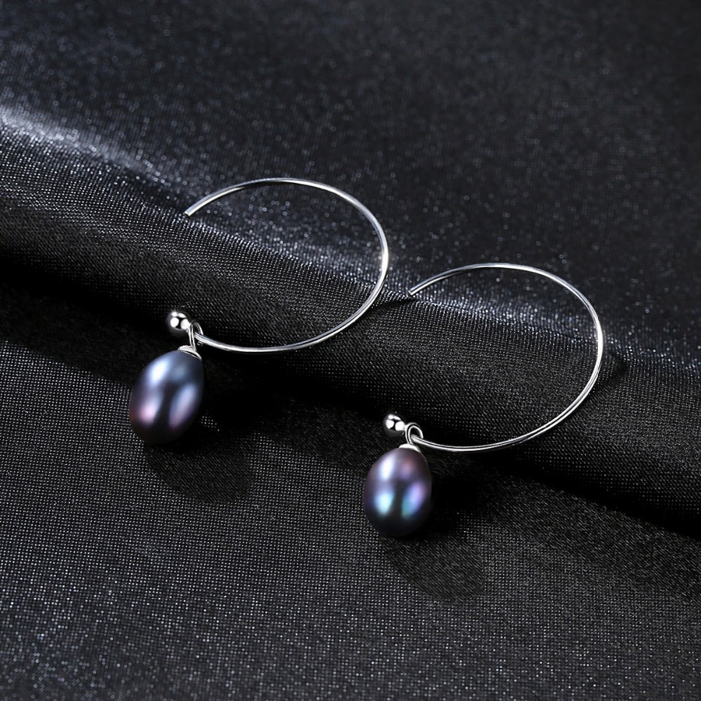 A pair of Maramalive™ Minimalist Earrings on a black surface.