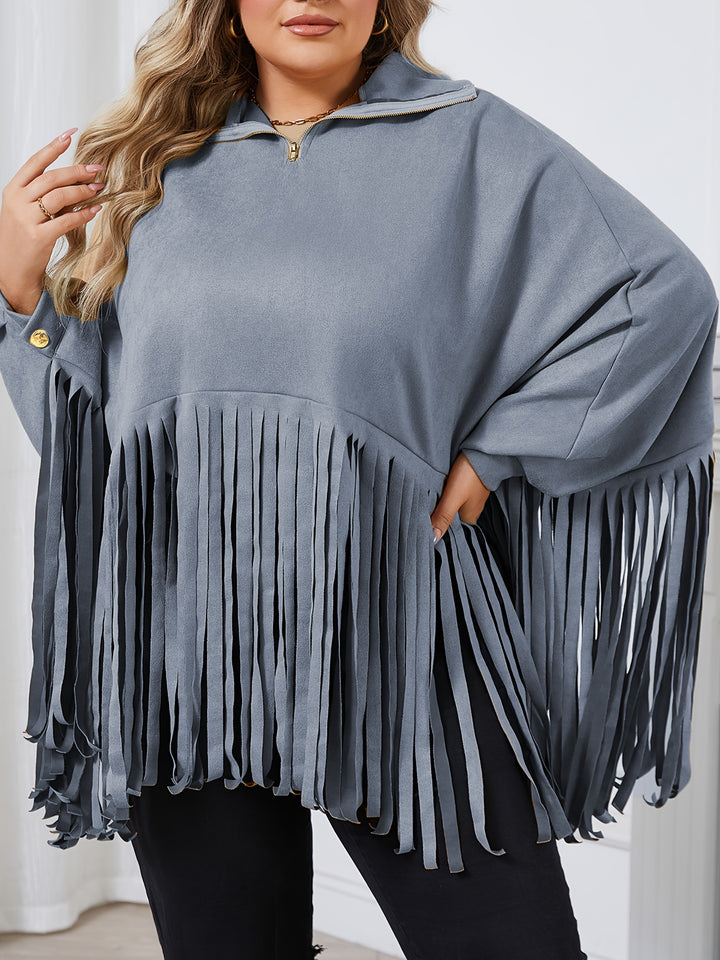 A person wearing a Maramalive™ Plus Size Trendy Top, Women's Plus Solid Batwing Sleeve Mock Neck Fringe Trim Cloak Top in light blue and black pants, perfect for Fall/Winter, with long wavy hair.