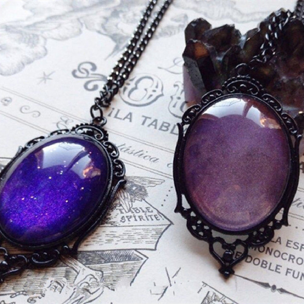 A Maramalive™ Plum Sunset Talisman: Purple Night Sky Gothic Necklace in a box with a cat on it.