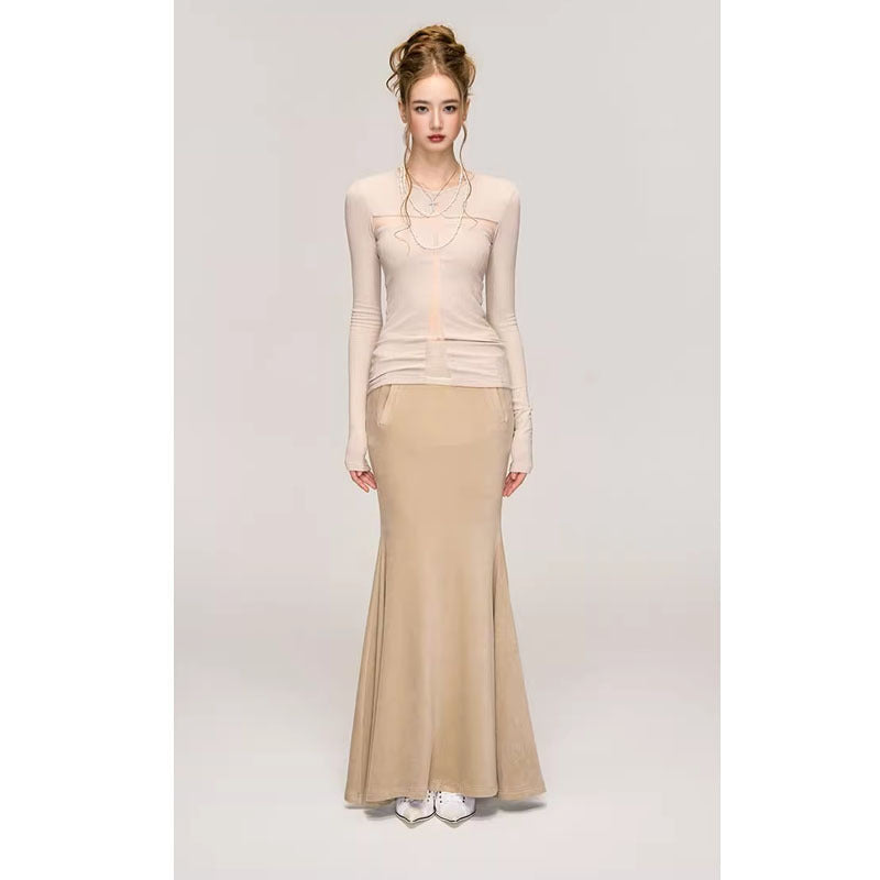 A woman with long hair is wearing a light beige Fashion Long Sleeve Bottoming Shirt For Women from Maramalive™ and a tan floor-length skirt made of polyester fabric. She completes her look with white shoes, standing against a plain, light-colored background.