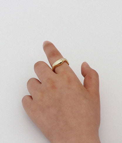 A Minimalist Cold Wind Ring for Women by Maramalive™ on a table next to a frame.