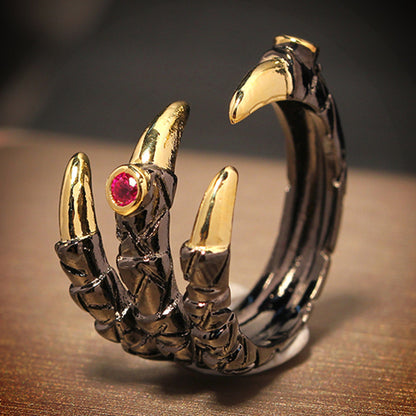 A Dragon Claw Ring from Maramalive™ with claws and a pink stone.
