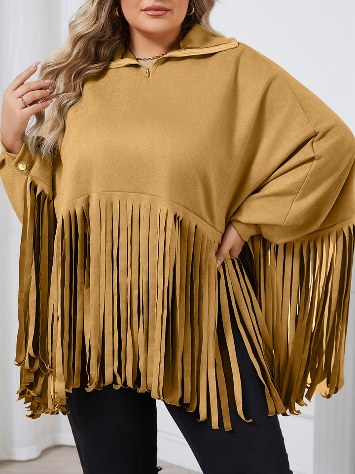 A person wearing a mustard-colored Maramalive™ Plus Size Trendy Top, Women's Plus Solid Batwing Sleeve Mock Neck Fringe Trim Cloak Top, posing with one hand on their hip and the other placed near their shoulder, against a plain background.