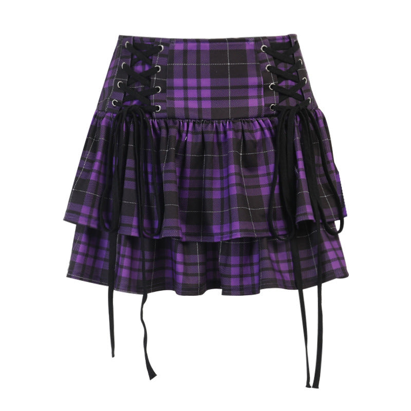 A woman in a Gothic Lace-up Plaid Skirt - Punk Dark Tartan Mini Skirt by Maramalive™ holding a cup.
