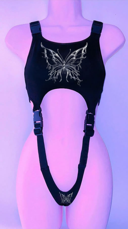 A '90s Throwback Y2K Gothic Style Cropped Vest for Goths from Maramalive™, featuring a silver butterfly design on the chest and crotch, along with adjustable straps and buckles, displayed on a mannequin under purple lighting. This vintage-inspired goth style piece adds an edgy yet elegant touch to any outfit.