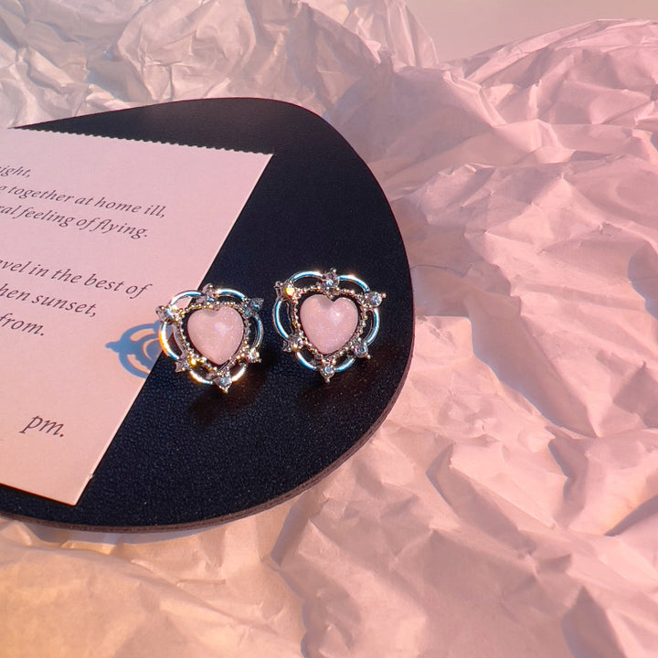 A pair of Sparkling Opal Heart Shape With Diamond Stud Earrings by Maramalive™ on a piece of paper.