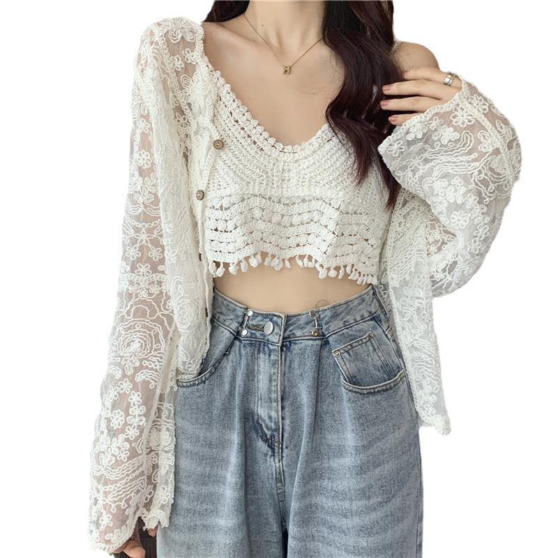 A person wearing the Maramalive™ Crocheted Two-piece Set Female Summer New Western Style Blouse Top adorned with crocheted flowers, paired with long sleeves and high-waisted blue jeans, captures the fresh and sweet style perfectly.