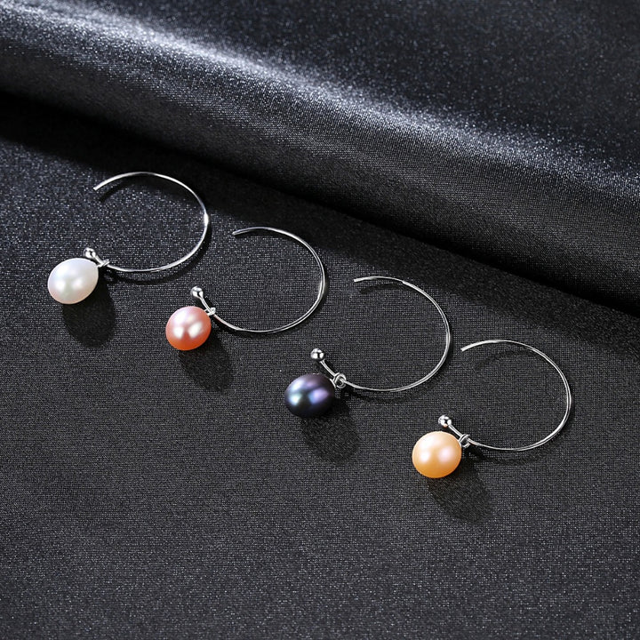 A pair of Maramalive™ Minimalist Earrings on a black surface.