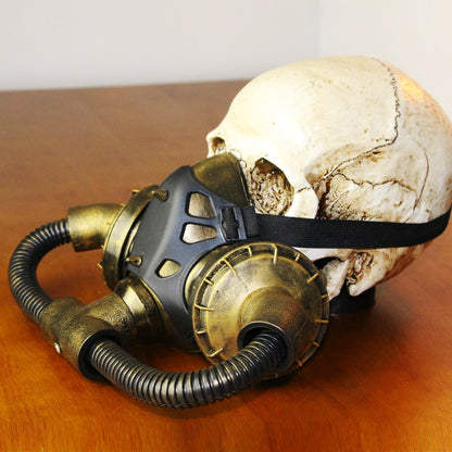 A Maramalive™ Steampunk Halloween Masquerade Mask with a gas mask on a wooden table.