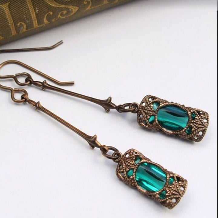 A pair of Maramalive™ Vintage bronze earrings with emerald green glass.