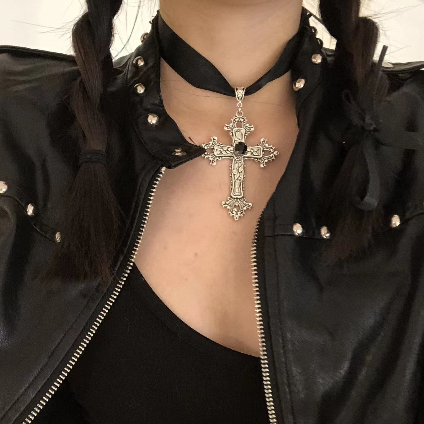 A woman wearing a black leather jacket with a Gothic Cross Ribbon Necklace from Maramalive™.
