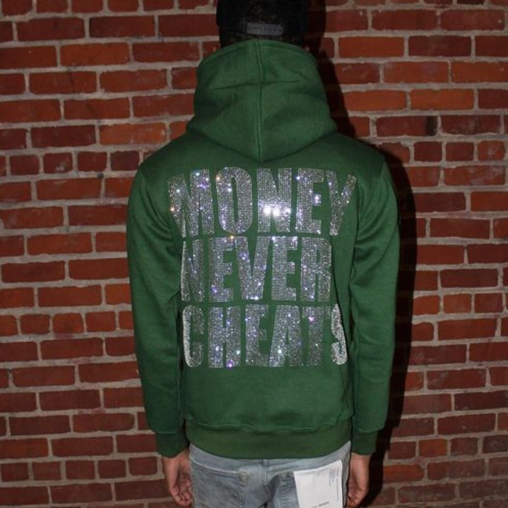 A street hipster wearing a green Maramalive™ Letter New Long-sleeve Zipper Hoodie Fashion Casual Punk Coat Sweatshirt with glittery text "MONEY NEVER CHEATS" stands facing a brick wall.