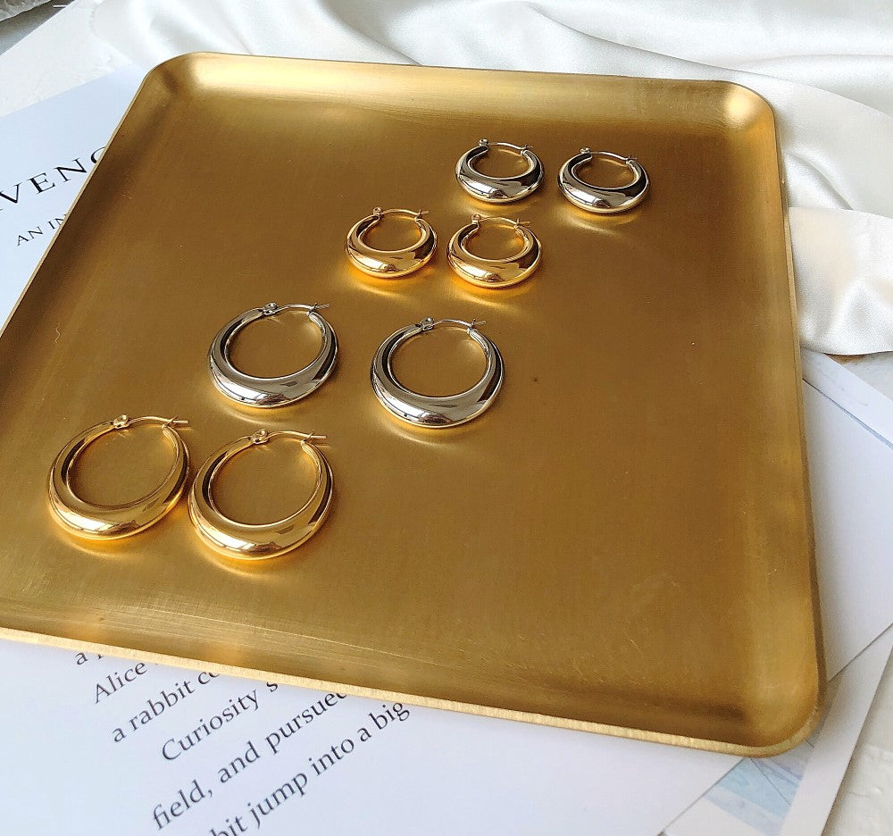 Luxury earrings by Maramalive™ on a gold tray.