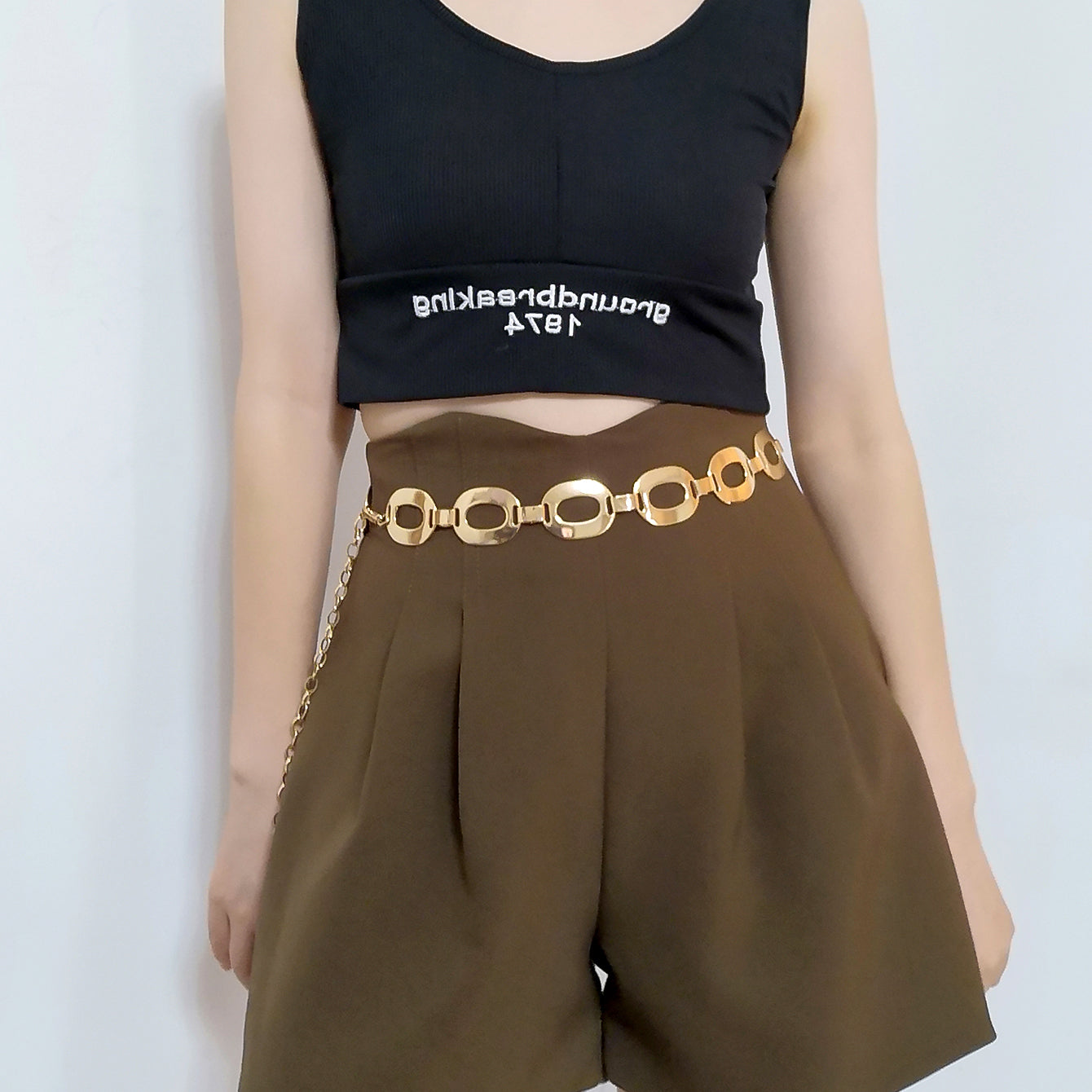 A woman wearing a black top and shorts with a Maramalive™ Popular and Trendy Summer Jewelry Waist, Navel Chain Metal Jewelry.