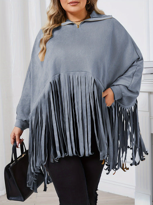 A person wearing a loose-fitting, long-sleeve, light blue Maramalive™ Women's Plus Solid Batwing Sleeve Mock Neck Fringe Trim Cloak Top with black pants, holding a black handbag—perfect for the Fall/Winter season.