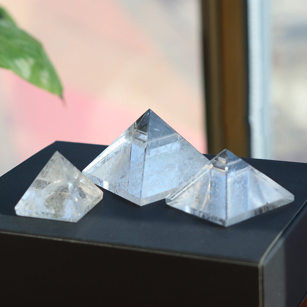 A set of Maramalive™ Quartz Crystal Pyramid Ornaments sitting on top of a wooden box.