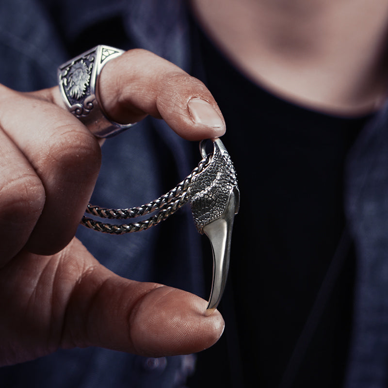 A man holding up a 925 Silver Wind Dragon Claw Pendant with a Maramalive™ tawny.