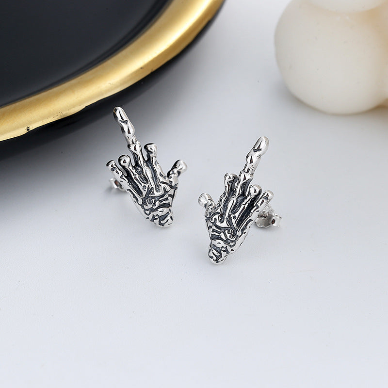 A pair of Exaggerated Gothic Dark Skull Hand Stud Earrings in Sterling Silver by Maramalive™ on a white background.