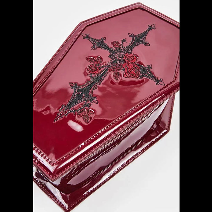 A girl in a burgundy velvet skirt and hoodie with a zipper was carrying the Maramalive™ Red Punk Gothic Patent Leather Embroidered Coffin Bag.