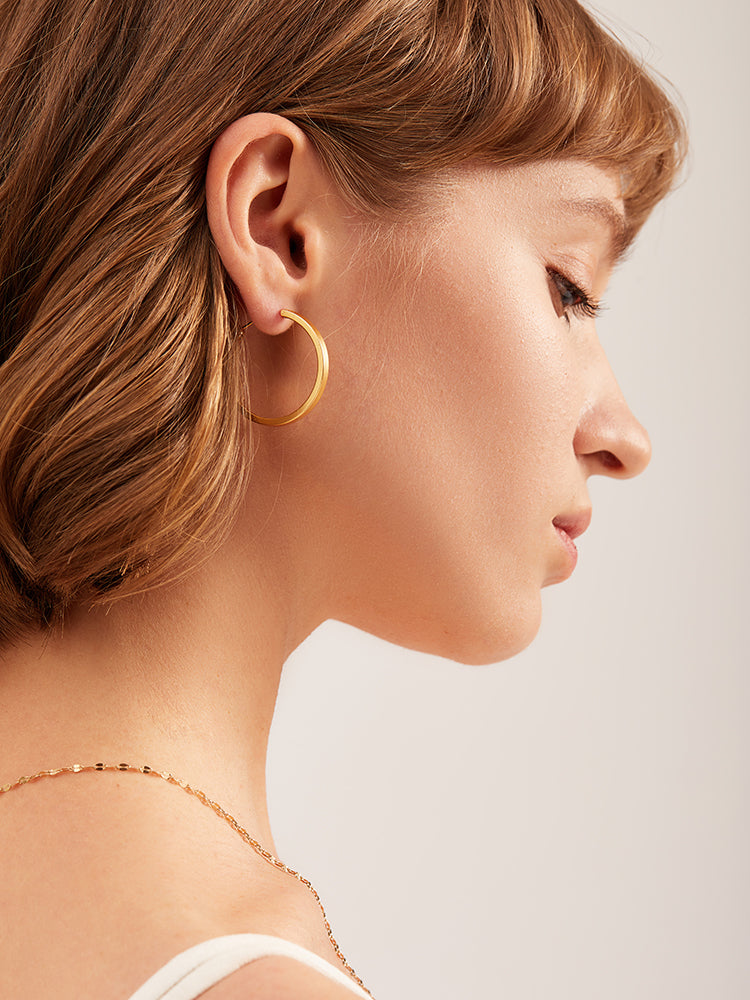 A pair of Maramalive™ Minimalist Circle Ear Buckle earrings on a white surface.