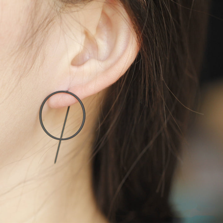 A woman wearing a pair of Maramalive™ Minimalist Copper Earrings.