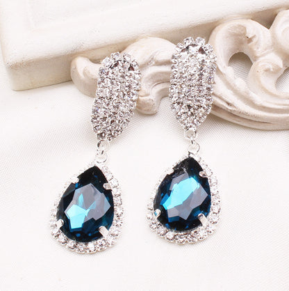 A pair of Maramalive™ Crystal Earrings with blue crystals and diamonds.