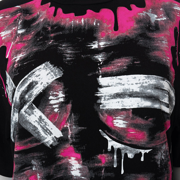 Close-up of the Maramalive™ Chic Oversized Short Sleeve Tees for Women in black fabric with abstract white and pink patterns, featuring large brushstroke-like white X marks and pink splash designs. This short sleeve top offers both style and comfort.