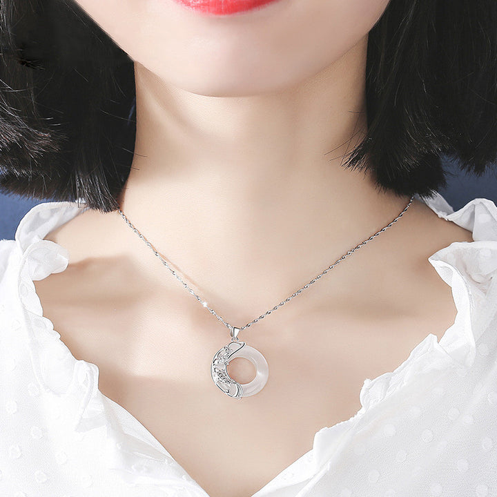 A woman wearing a Maramalive™ Women's Lucky Pendant Moonstone Necklace with an electroplated water wave chain.