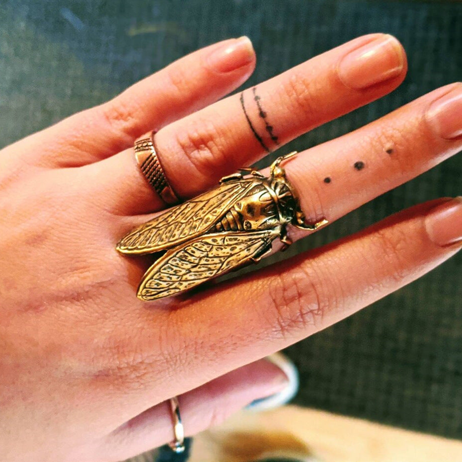 A woman's hand with a Maramalive™ Adjustable Gothic Cicada Ring on it.