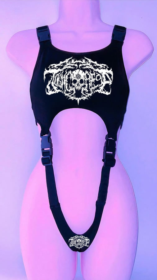 A mannequin wearing a Maramalive™ '90s Throwback Y2K Gothic Style Cropped Vest for Goths made of black faux leather material, adorned with metal buckles and white graphic designs on the chest and lower part, is displayed against a purple background.