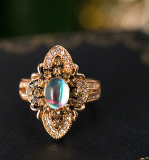 A Moonstone Crystal Ring from Maramalive™ with an opal and black diamonds.