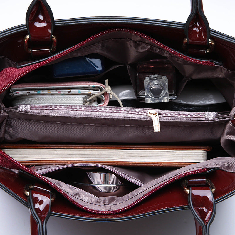 The burgundy patent leather handbag by Maramalive™ features a crocodile pattern and a zipper pocket.