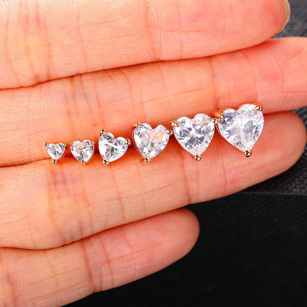 Three Heart Zircon Stud Earrings by Maramalive™ in a person's hand.