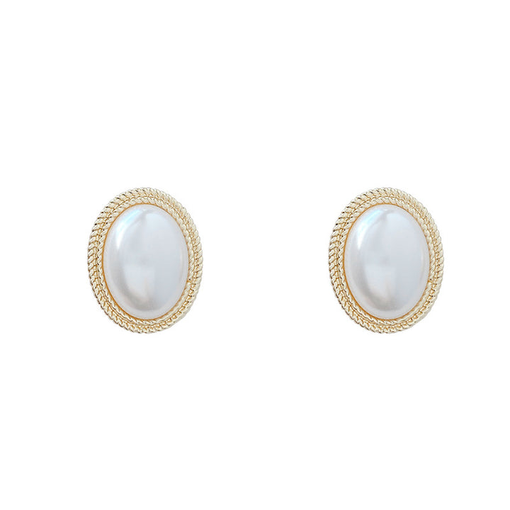 A hand holding a pair of Maramalive™ French Baroque Pearl Earrings.