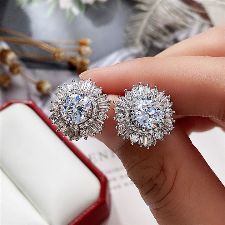 A woman's hand holding a pair of Maramalive™ New High-end Luxury Full Rhinestone Zircon Snowflake Earrings.