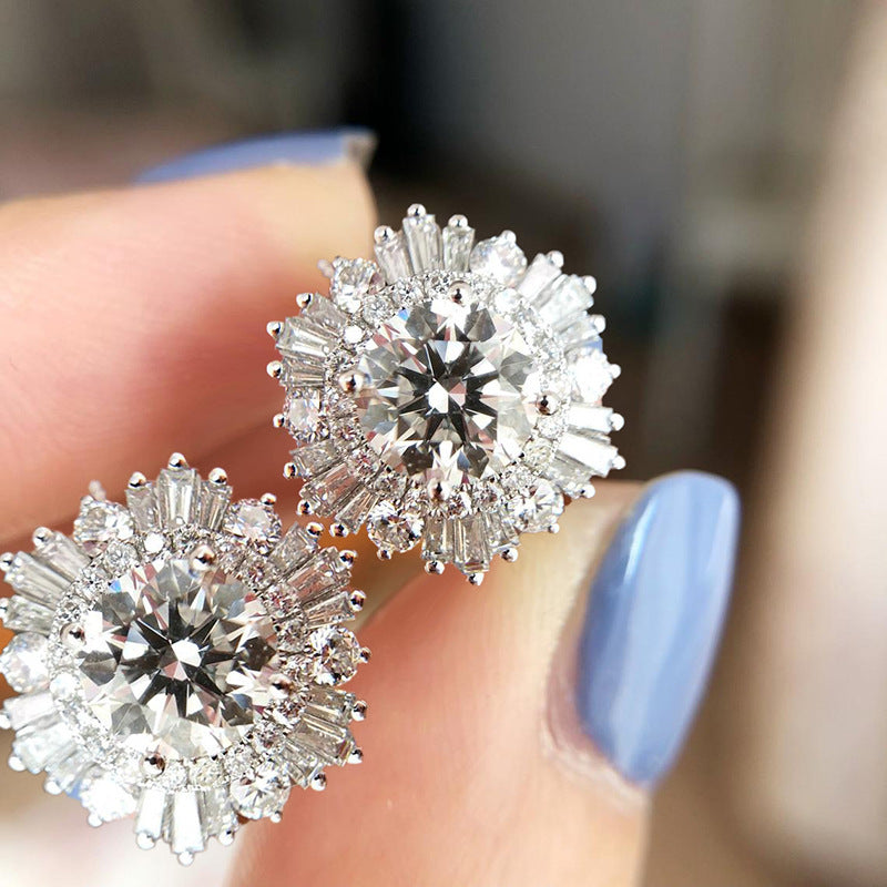 A woman's hand holding a pair of Maramalive™ New High-end Luxury Full Rhinestone Zircon Snowflake Earrings.