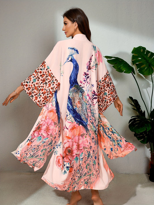 A person is shown from the back, wearing a Maramalive™ Bohemian Style Women's Peacock Print Beach Cover-Up With Belt, Long Sleeves Loose Fit Vacation Kimono adorned with a colorful peacock and floral design. They are standing indoors near a green leafy plant, giving off boho tunic vibes.