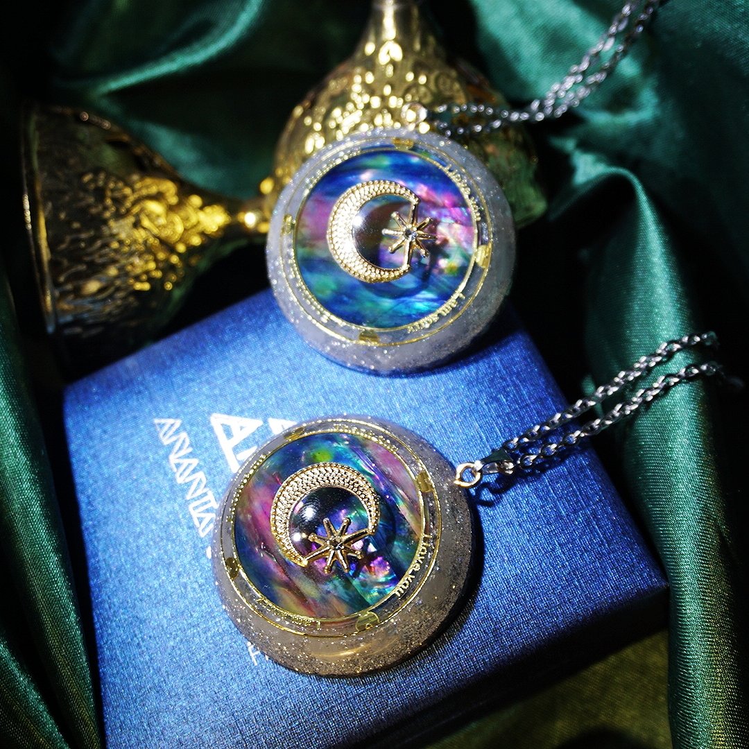 A pair of Maramalive™ Handmade Crystal Pendant Necklace Sweater Chains with a moon and star on them.
