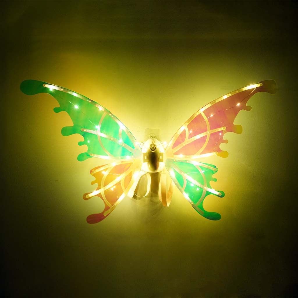 A little girl in a fairy costume standing next to a table wearing Maramalive™ Electric Wings Luminous Elf Wings FARCENT Angel Wings Children's Outdoor Stage Props.