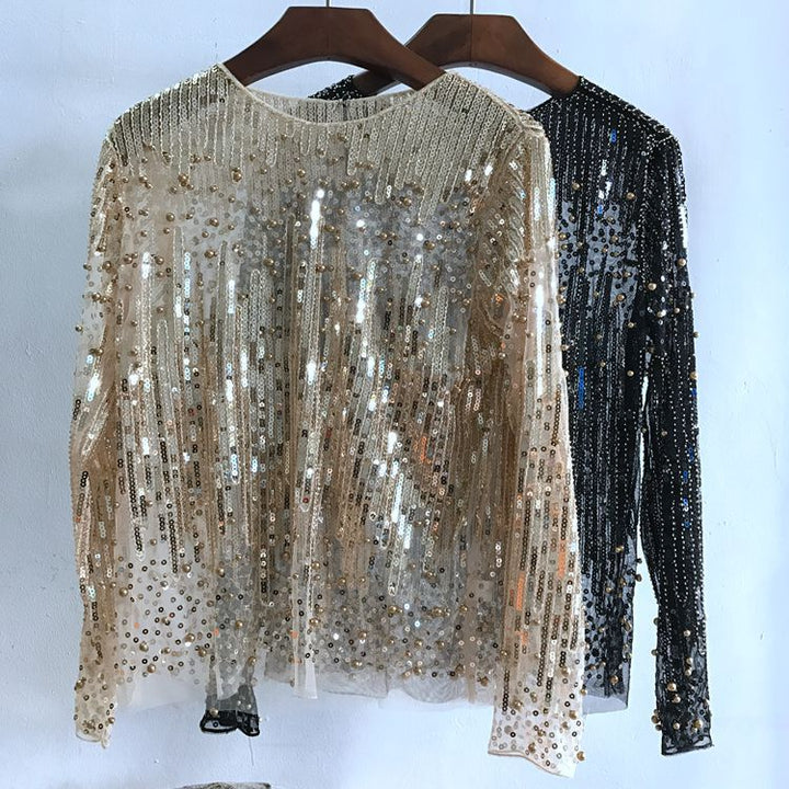 Two sequin-covered women's tops on hangers: one is white with gold sequins arranged in vertical lines, and the other is black with silver sequins. Both are made from polyester fiber and hang against a light wall. These are Maramalive™ Fashion Bottoming Shirt Sequined Tops For Women.