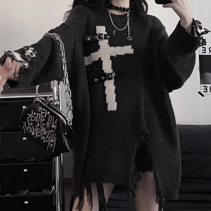 Person wearing an oversized black Maramalive™ Dark Cross Loose Sweater - Comfortable Fit for Women with a white cross design, made from a soft cotton-blend fabric, paired with black shorts, and holding a black handbag with metal accents.