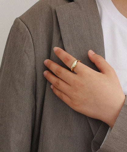 A Minimalist Cold Wind Ring for Women by Maramalive™ on a table next to a frame.