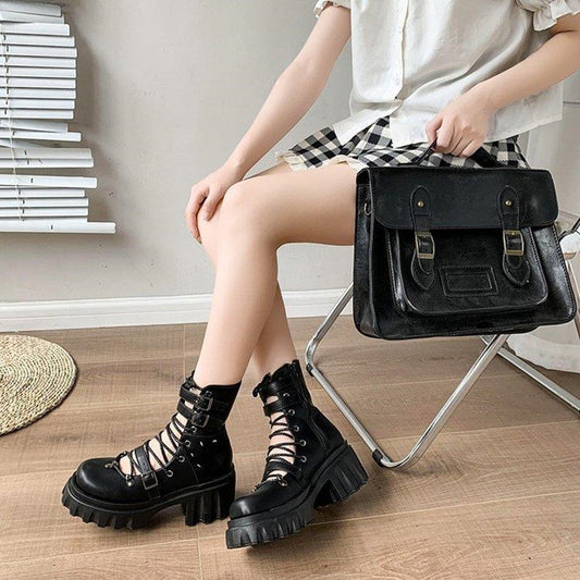 A woman is sitting on a chair holding a Maramalive™ Gothic Hollow Out Martin Boots Women platforms.