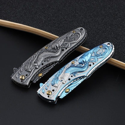 Two Maramalive™ Outdoor Survival Knife Camping Mermaid Folding with different designs on top of a skateboard.